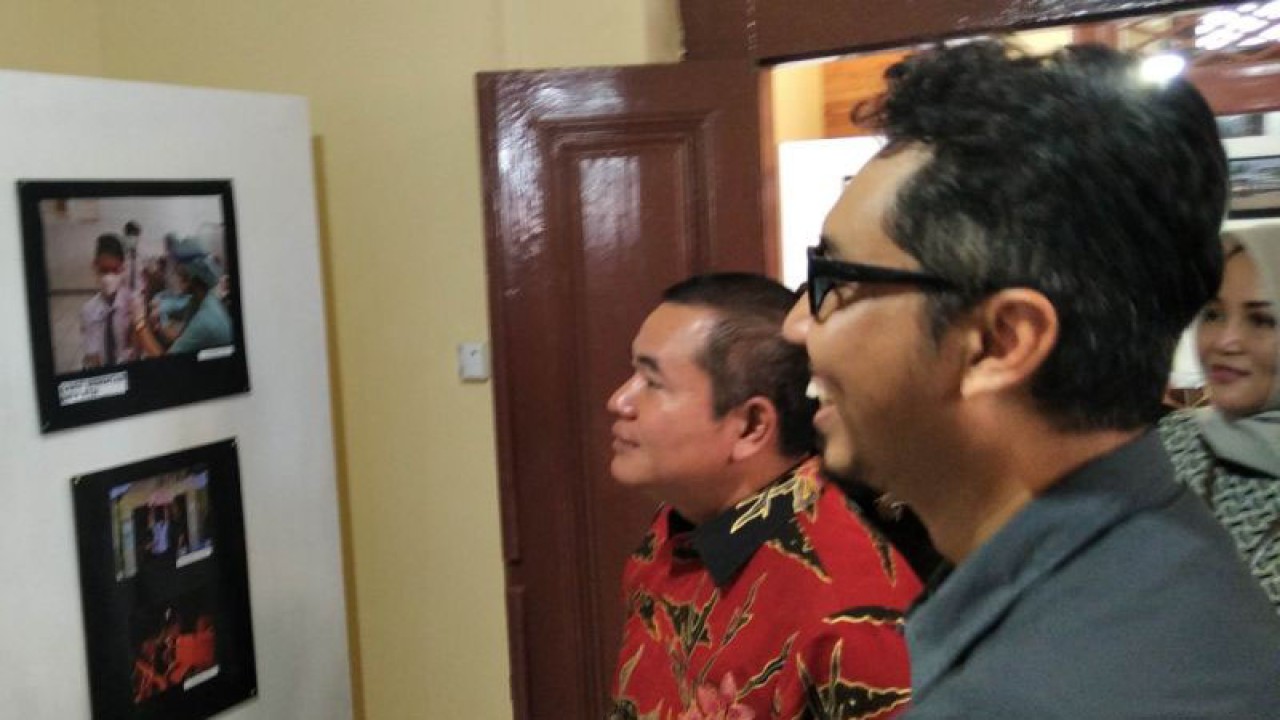 Ketua DPRD Kudus Masan didampingi Ketua PWI Kabupaten Kudus Saiful Annas melihat foto karya pewarta Kudus pada pameran foto bertajuk "Kudus dalam Bingkai" yang berlangsung pada 20-22 Desember 2022 di Kantor Dewan Kerajinan Nasional Daerah (Dekranasda) Kabupaten Kudus, Selasa (20/12/2022) . ANTARA/Akhmad Nazaruddin Lathif.