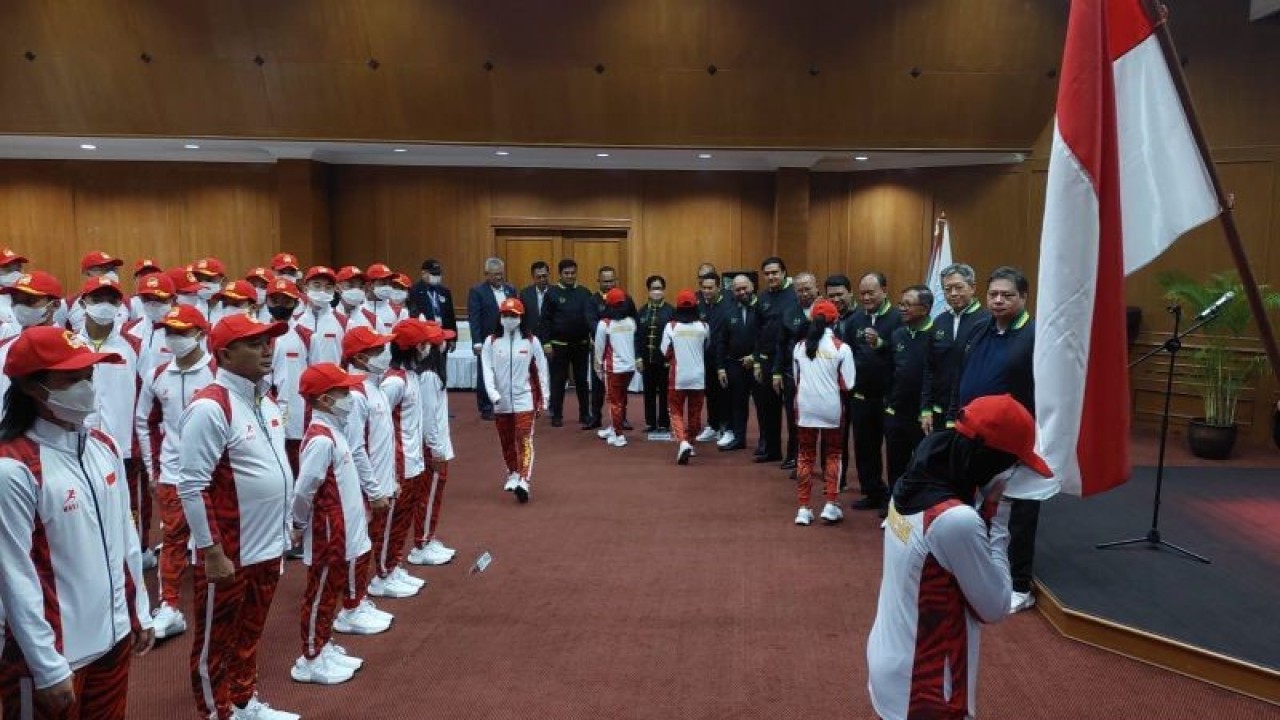 Atlet Indonesia mencium bendera Merah Putih dalam acara pelepasan Kontingen Indonesia untuk Kejuaraan Dunia Wushu Junior 2022 di kawan Widya Chandra, Jakarta, Kamis (1/12/2022). (ANTARA/Muhammad Ramdan)