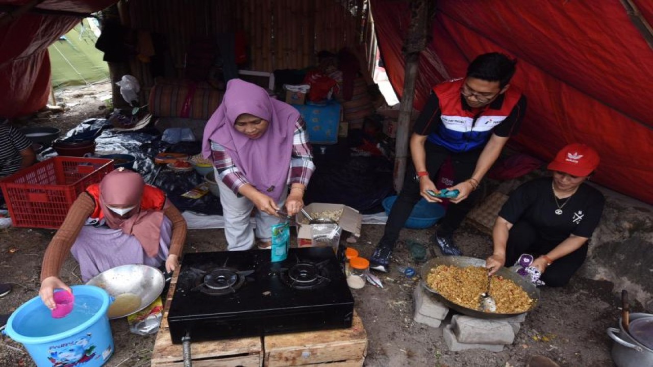 Sejumlah relawan memasak makanan untuk para pengungsi korban gempa bumi di Kampung Panembong Kaler, Desa Mekarsari, Cianjur, Jawa Barat. (ANTARA/HO-Pertamina)