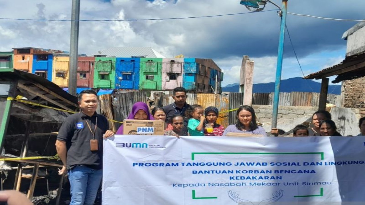 Pimpinan PNM Cabang Ambon Ridul Akbar (kiri) menyalurkan bantuan untuk nasabah PNM Mekaar yang jadi korban kebakaran di kawasan Lorong Tahu Pasar Mardika, Kota Ambon. (ANTARA/John Soplanit)