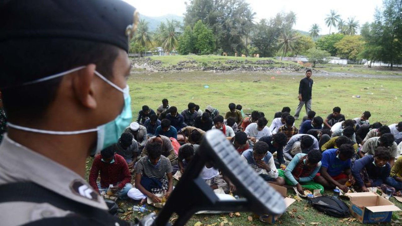 Ilustrasi - Polisi memberikan pengamanan kepada 57 imigran etnis Rohingya setelah terdampar di pantai Desa Ladong, Kabupaten Aceh Besar, Aceh, Minggu (25/12/2022). ANTARA FOTO/Ampelsa