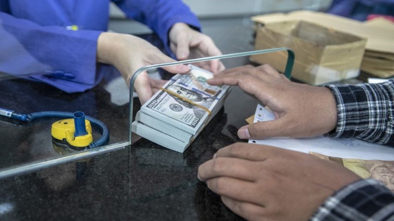 Petugas memberikan uang pecahan dolar AS kepada pembeli di gerai penukaran mata uang asing VIP (Valuta Inti Prima) Money Changer, Jakarta, Selasa (4/10/2022). ANTARA FOTO/Muhammad Adimaja/aww.