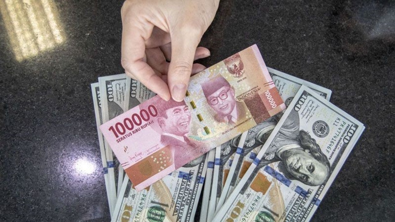 Ilustrasi - Petugas menunjukan uang pecahan Rupiah dan dolar AS di gerai penukaran mata uang asing VIP (Valuta Inti Prima) Money Changer, Jakarta, Selasa (4/10/2022). ANTARA FOTO/Muhammad Adimaja/aww/pri.