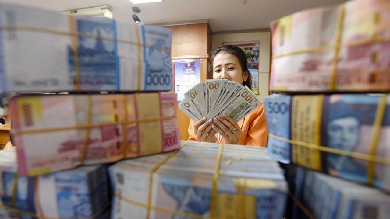 Seorang wanita menghitung uang transaksi penukaran Dolar AS dengan Rupiah di Jakarta, Senin (3/8). ANTARA FOTO/Akbar Nugroho Gumay/Rei/foc/15. (ANTARA FOTO/Akbar Nugroho Gumay)