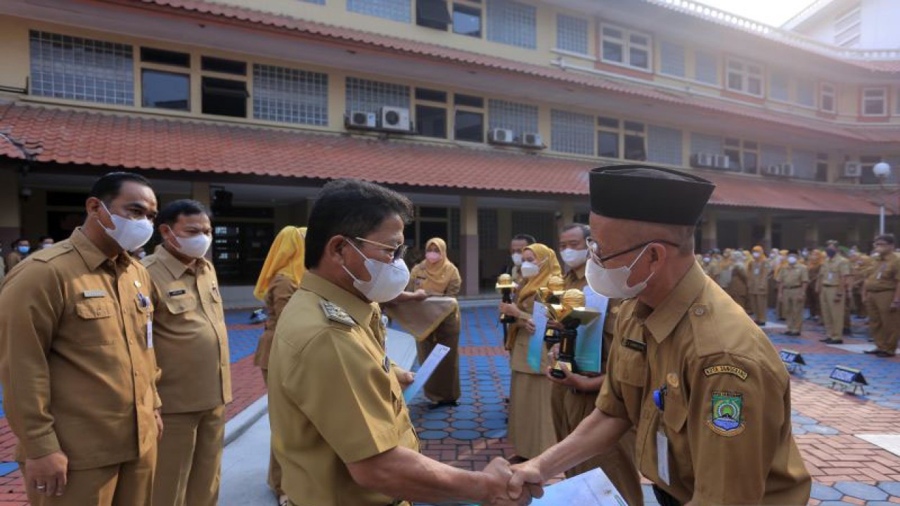 Wakil Wali Kota Tangerang Sachrudin (kiri) memberikan penghargaan kepada kepala sekolah atas keberhasilan sekolahnya meraih program Adiiwyata dalam kegiatan yang dilaksanakan di Tangerang, Senin (5/12/2022). (ANTARA)
