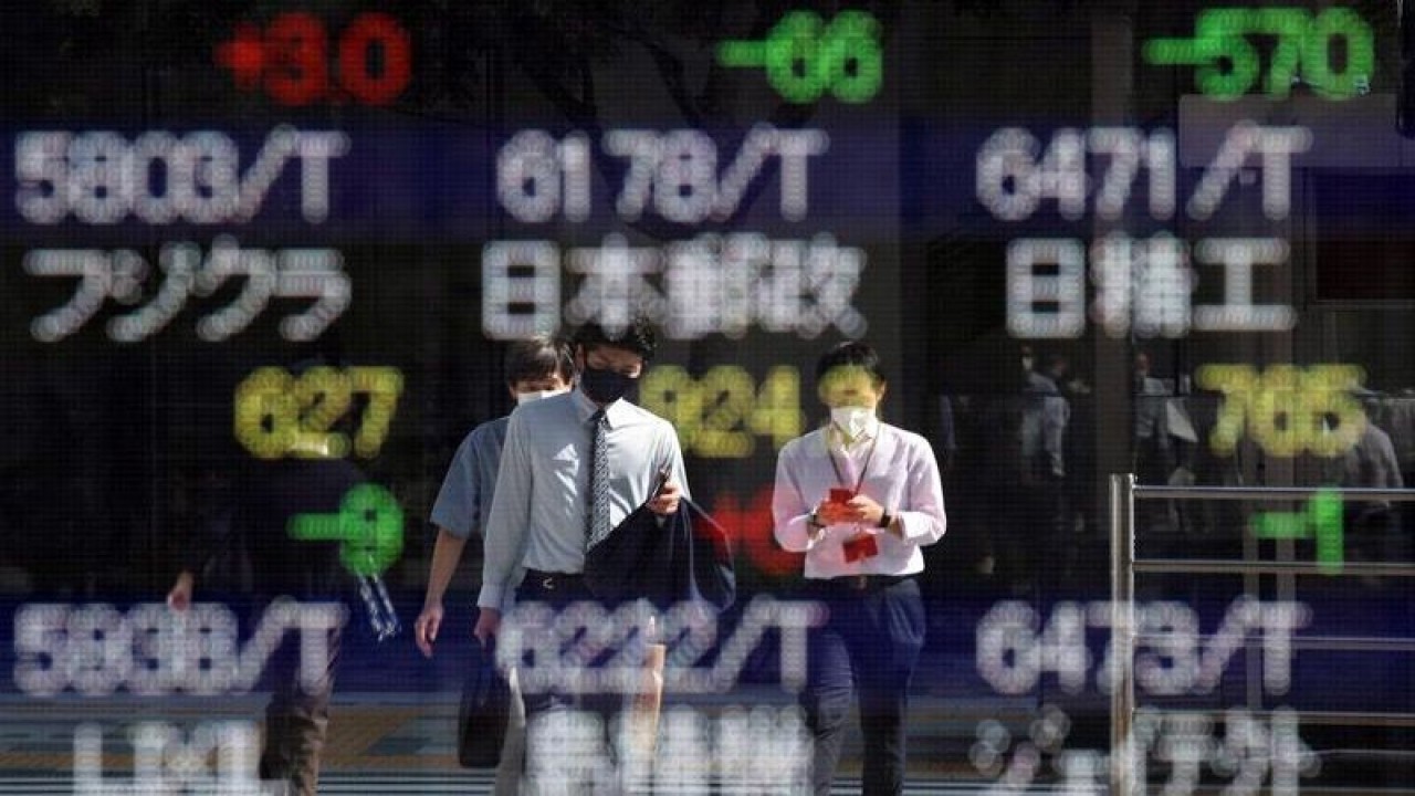 Arsip Foto - Sejumlah pekerja yang memakai masker pelindung, di tengah wabah penyakit virus corona (COVID-19), tercermin pada papan elektronik yang menampilkan harga saham Jepang di luar sebuah pialang di Tokyo, Jepang, Selasa (5/10/021). ANTARA/REUTERS/Kim Kyung-Hoon/am.