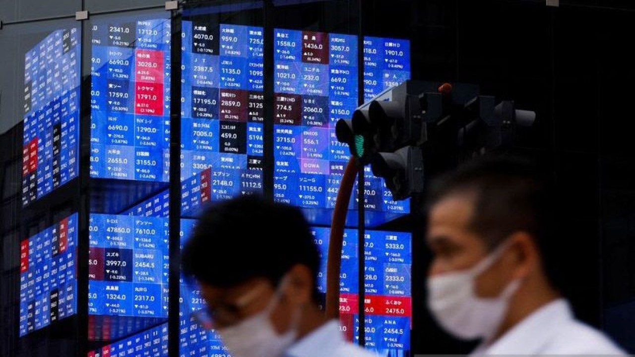 Arsip Foto - Orang-orang melewati layar elektronik yang menunjukkan indeks harga saham Nikkei Jepang di dalam sebuah aula konferensi di Tokyo, Jepang, Selasa (14/6/2022). ANTARA/REUTERS/Issei Kato/am.