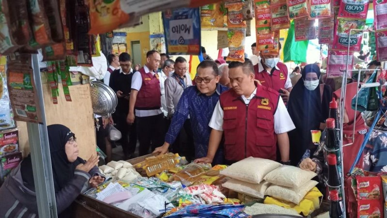 Kasatgas Pangan NTB Kombes Pol. Nasrun Pasaribu (ketiga kanan) dan Karo Perekonomian Setda NTB Wirajaya Kusuma (keempat kanan) bersama pejabat TPID NTB mengecek stok dan harga bahan pokok kepada pedagang di Pasar Kebon Roek, Mataram, Selasa (27/12/2022). (ANTARA/Dhimas B.P.)