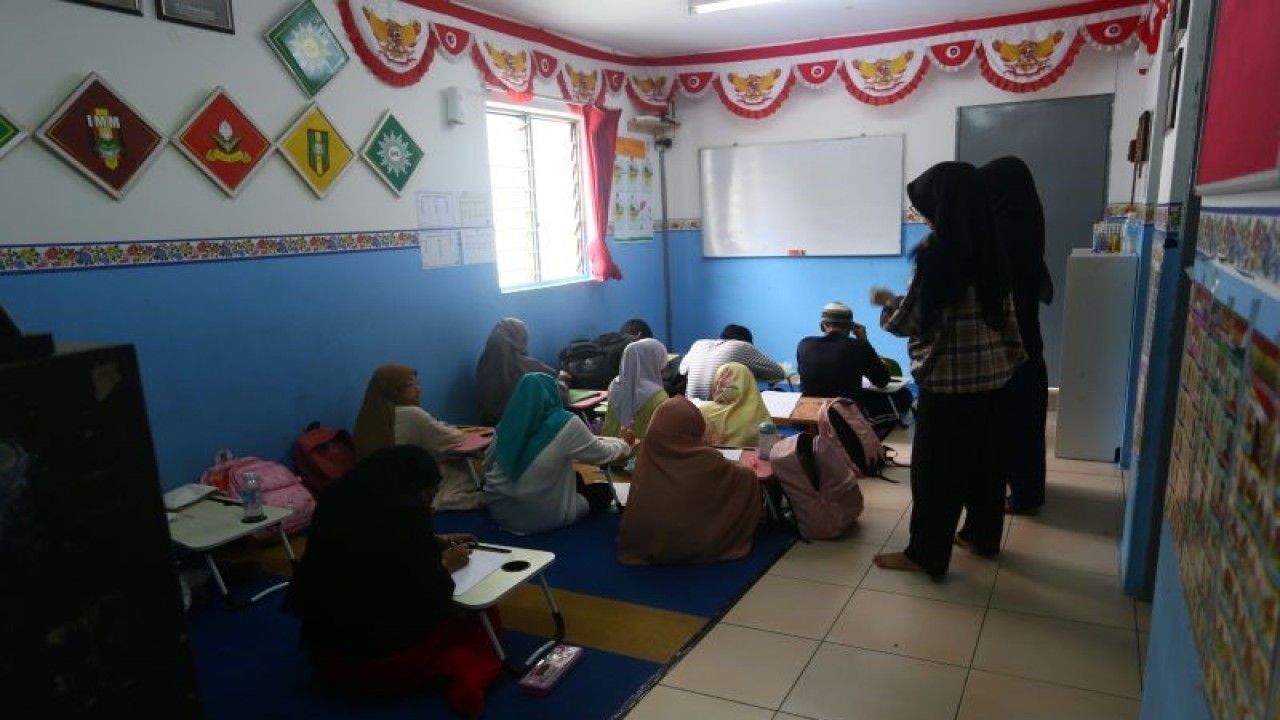 Mahasiswa Universitas Muhammadiyah Ponorogo asal Jawa Timur yang sedang melakukan Kuliah Kerja Nyata untuk mengawasi anak-anak tentang Pendidikan Pancasila dan Kewarganegaraan di Sanggar Bimbingan Kepong, Kuala Lumpur, Rabu (14/12/2022). (ANTARA/Virna P Setyorini)