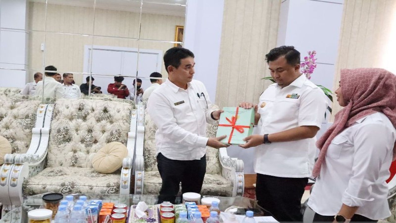 Bupati Dharmasraya, Sutan Riska Tuanku Kerajaan (tengah) didampingi Kepala Dinas Perkimtan Silaturahhim (kanan), dan Kepala ATR/BPN Ahmad Yahdi (kiri) saat penyerahan sertifikat aset pemda, di Ruang Kerja Bupati Dharmasraya, di Pulau Punjung, Rabu(13/12/2022). ANTARA/HO-Dinas Perkimtan Dharmasraya
