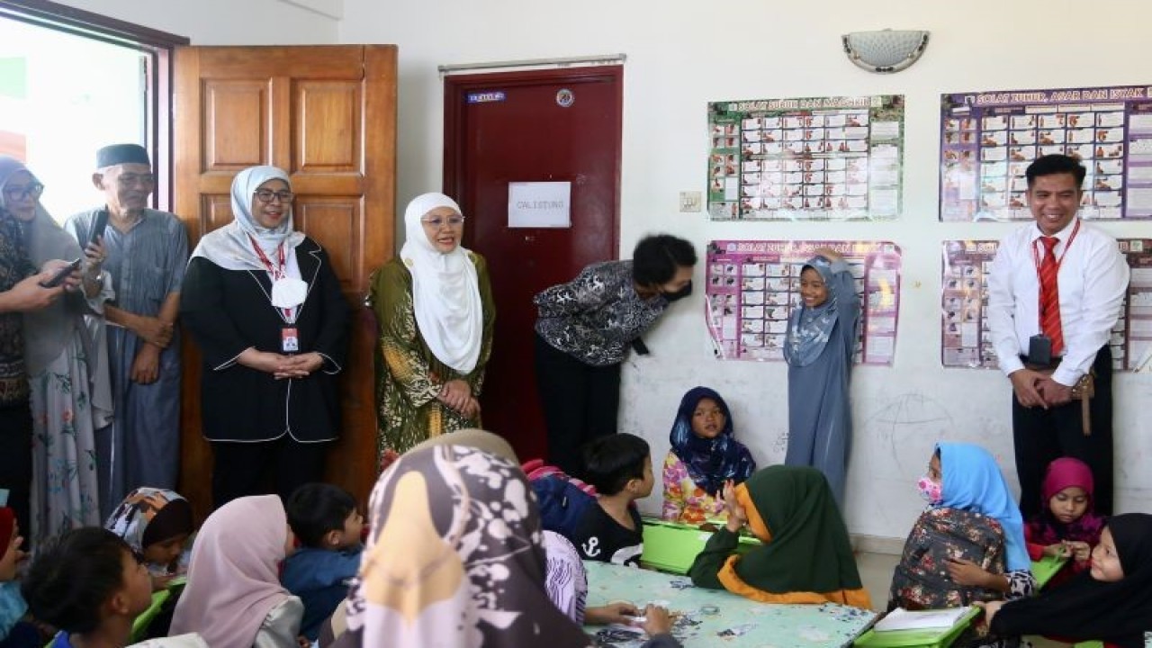 Sekretaris Kementerian Pendidikan Kebudayaan Riset dan Teknologi Suharti (membungkukkan tubuh) berbicara dengan salah satu anak dari Sanggar Bimbingan Sungai Mulia 5 di Kuala Lumpur, Senin (19/12/2022). (ANTARA/Virna P Setyorini)