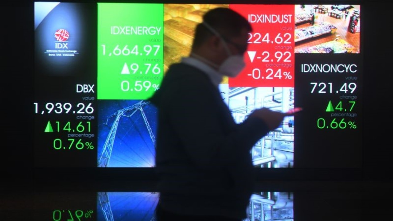 Seorang pria melintasi layar digital pergerakan saham di Bursa Efek Indonesia, Jakarta, Jumat (24/6/2022). ANTARA FOTO/Akbar Nugroho Gumay/foc.