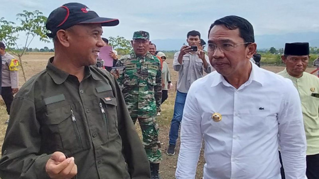 Bupati Sigi Mohamad Irwan (kemeja putih) bersama Kepala Dinas Tanaman Pangan Hortikultura dan Perkebunan Kabupaten Sigi Rahmad Iqbal Nurkhalis, di sela-sela penanaman jagung yang dirangkaikan dengan penyaluran alat mesin pertanian, di Desa Karawana, Kecamatan Dolo, Kabupaten Sigi, Jumat (30/12/2022) (ANTARA/Muhammad Hajiji)