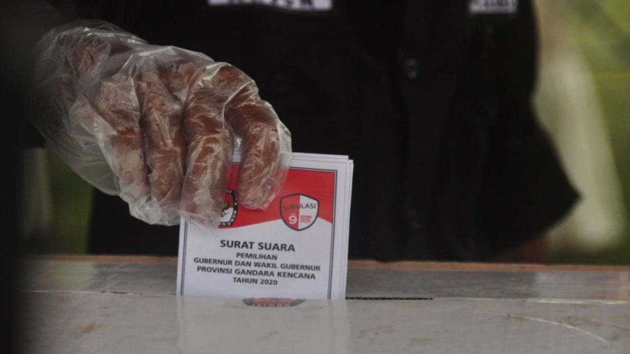 Seorang pemilih memasukkan surat suara ke dalam kotak suara usai melakukan pencoblosan di bilik pada simulasi pemungutan dan penghitungan suara. ANTARA/Moh Ridwan