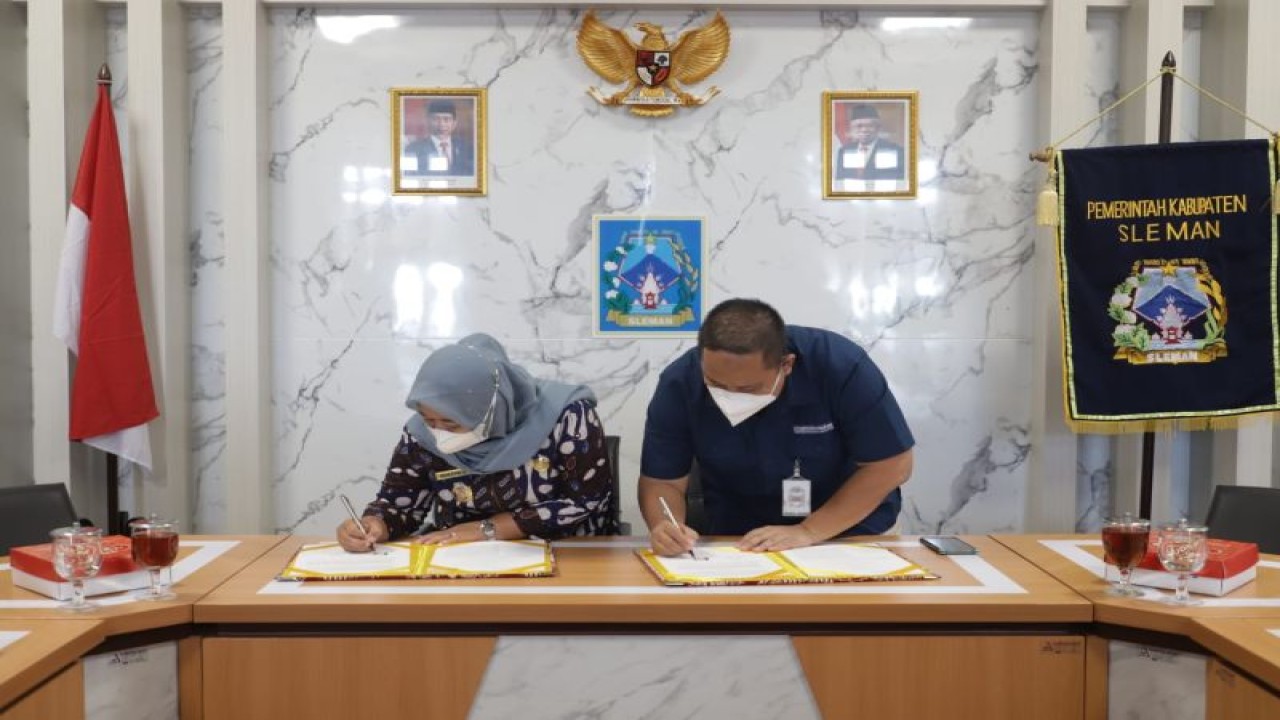 Bupati Sleman Kustini Sri Purnomo bersama Kepala BPJS Kesehatan Sleman Idar Aries Munandar melakukan penandatanganan kesepakatan bersama penyelenggaraan Jaminan Kesehatan Nasional bagi masyarakat Kabupaten Sleman terkait pelaksanaan UHC di Sleman, Kamis (15/12/22). ANTARA/HO-Bagian Prokopim Setda Sleman