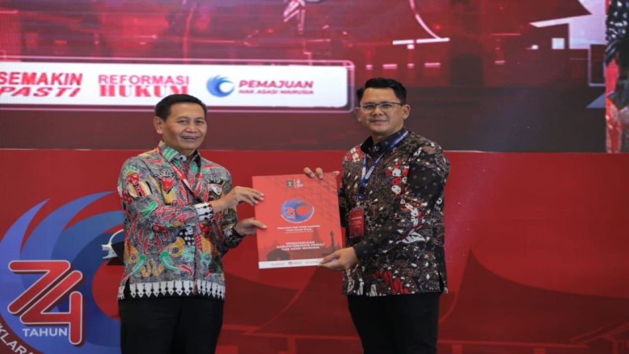 Wakil Bupati Sleman Danang Maharsa menerima penghargaan Kabupaten Peduli HAM dari Dirjen HAM Kemenkumham Mualimin Abdi dalam acara Peringatan Hak Asasi Manusia Sedunia ke-74 di Jakarta, Senin (12/12/22). (ANTARA/HO-Setda Sleman)