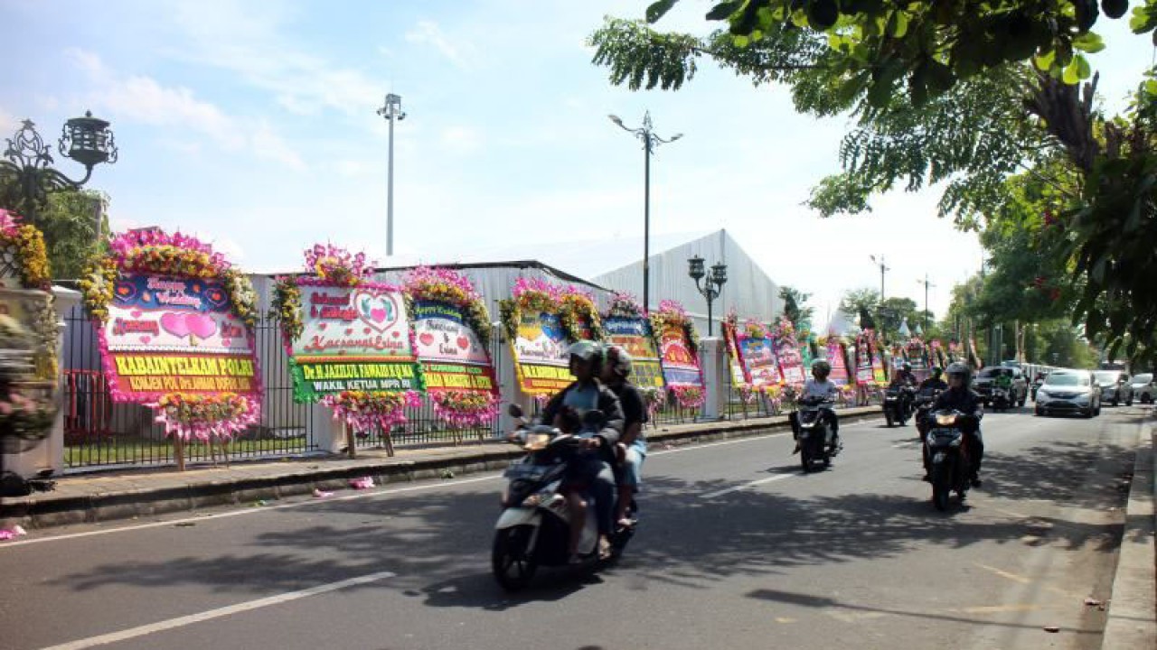 Sejumlah masyarakat melintas di tempat tasyakuran pernikahan Kaesang-Erina di Jalan Ronggo Warsito atau depan Pura Mangkunegaran Surakarta, Sabtu (10/12/2022). ANTARA/Bambang Dwi Marwoto.