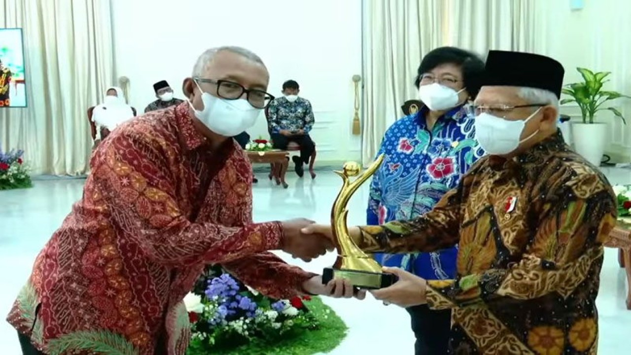 Wakil Presiden RI Ma'ruf Amin (kanan) menyerahkan trofi Proper Emas Tahun 2022 kepada Direktur Utama PT Solusi Bangun Indonesia Tbk Lilik Unggul Raharjo (kiri) di Istana Wakil Presiden, Jakarta, Kamis (29/12/2022). ANTARA/HO-SBI