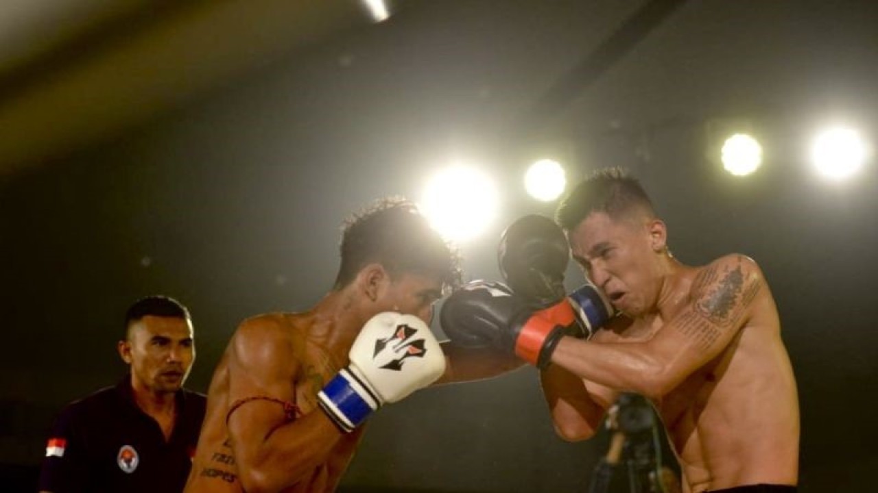 Petarung Muay Thai profesional Rahman “Super Saiya” Husin (kanan) melepas pukulan ke lawannya Maruli “The Gangster” Nainggolan (dua kanan) pada laga tarung bebas profesional Summer Fights di International Conference Center Bali, Kuta, Badung, Minggu (18/12/2022). ANTARA/Fikri Yusuf