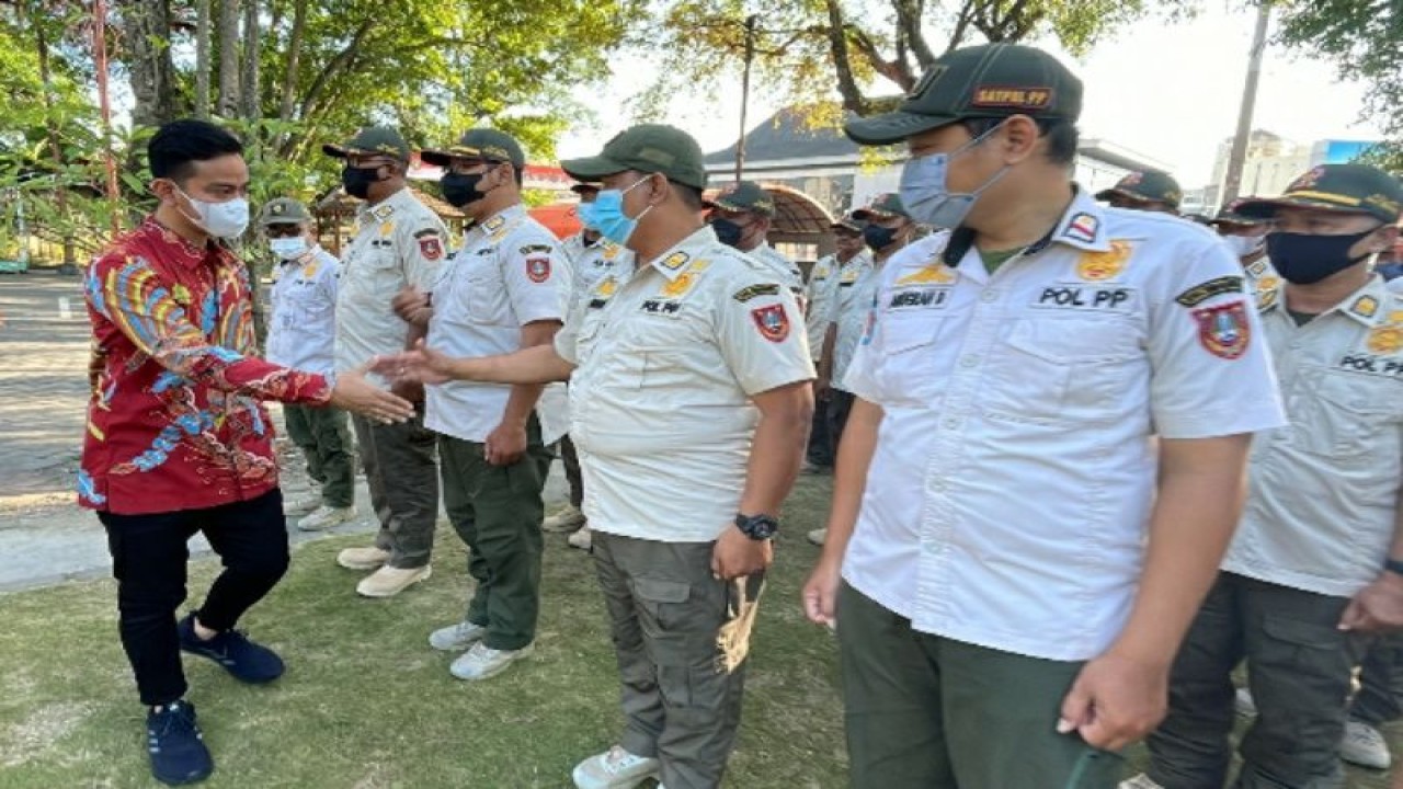 Wali Kota Surakarta Gibran Rakabuming Raka menyalami salah satu petugas Satpol PP pada Apel Gelar Pasukan Pengamanan Natal 2022 dan Tahun Baru 2023 di Halaman Balai Kota Surakarta, Selasa (20/12/2022). ANTARA/HO-Pemkot Surakarta