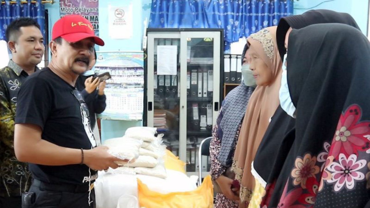 Plt Kepala Dinas Ketahanan Pangan Kalsel Syamsir Rahman (topi merah) saat melaksanakan pembagian beras gratis ke warga untuk penanganan inflasi di Banjarmasin, Sabtu lalu (ANTARA/HO)