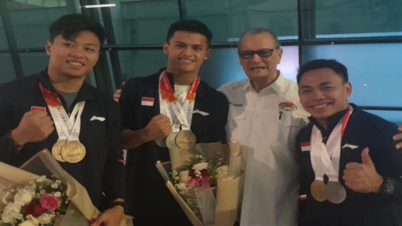 Sekjen PB PABSI Djoko Pramono (kedua dari kanan) bersama lifter peraih medali di Kejuaraan Dunia Angkat Besi 2022 yakni dari kiri Rahmat Erwin Abdullah, Rizki Juniansyah, dan Eko Yuli Irawan di Bandara Soekarno-Hatta, Tangerang, Banten, Sabtu (17/12/2022). (ANTARA/HO-PABSI)