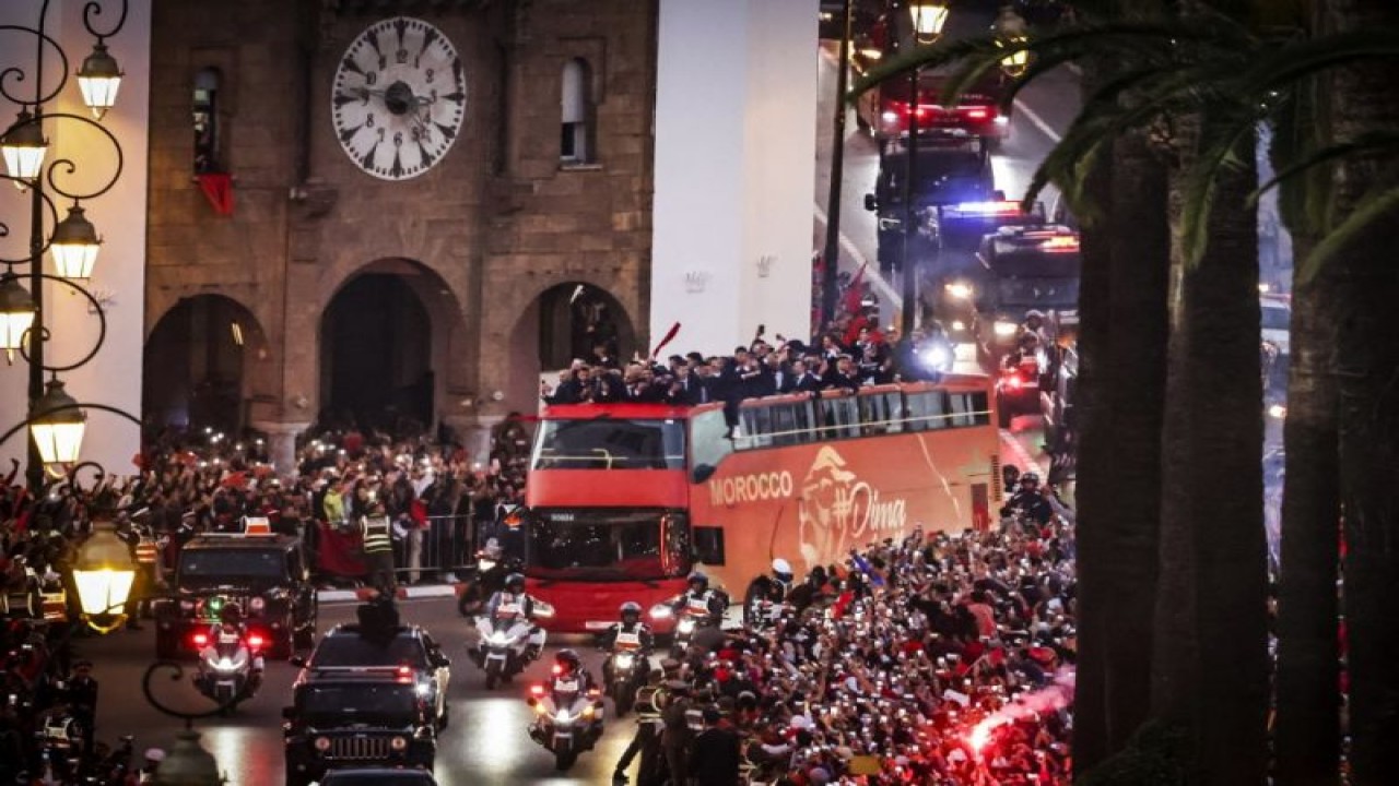 Para pendukung menyambut parade tim nasional Maroko di ibu kota Rabat pada 20 Desember 2022 setelah sukses mereka mencapai semifinal Piala Dunia Qatar 2022. (Photo by FADEL SENNA/AFP) (AFP/FADEL SENNA)