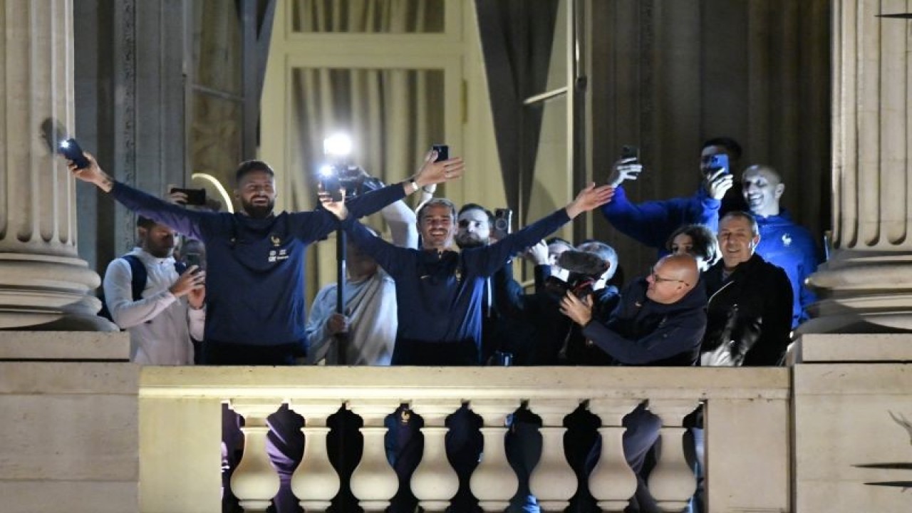 Penyerang timnas Prancis Olivier Giroud (kiri) dan Antoine Griezmann (tengah) menyapa para suporter di Hotel de Crillon, Paris, Prancis sehari setelah pertandingan final Piala Dunia 2022 di Qatar pada 19 Desember 2022. ANTARA/AFP/JULIEN DE ROSA