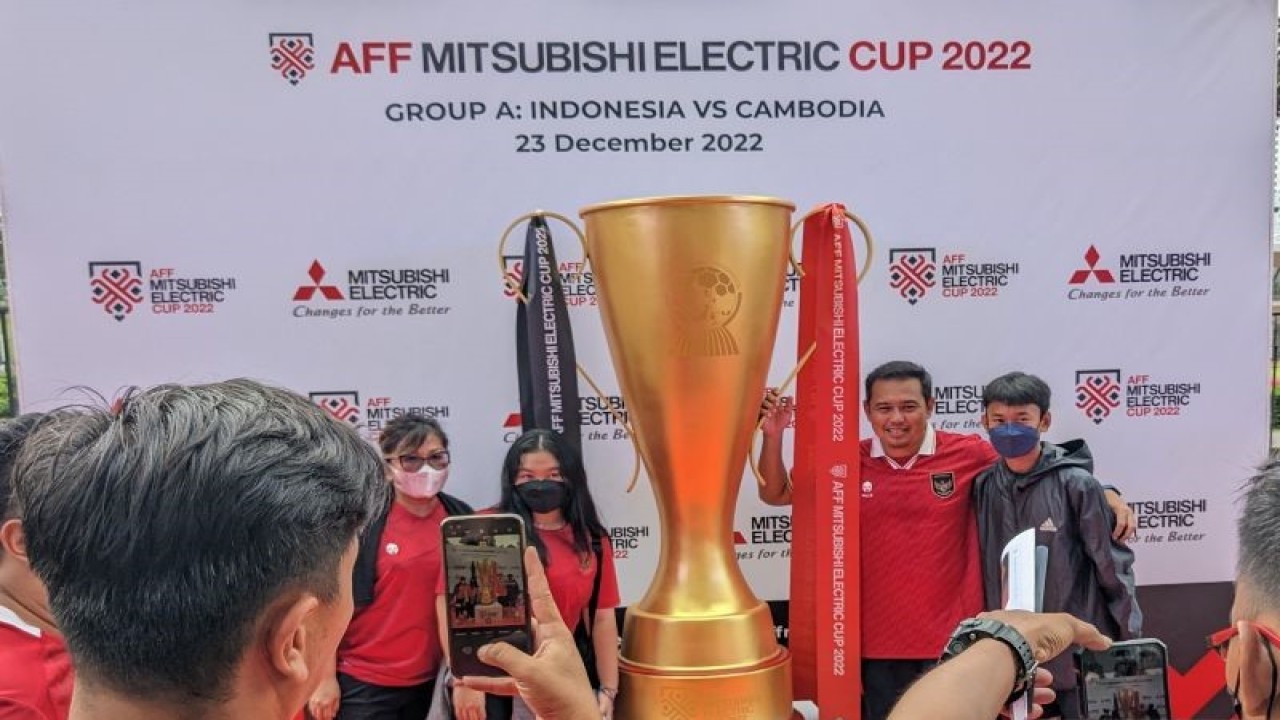 Para suporter tim nasional Indonesia berfoto dengan trofi Piala AFF raksasa di Stadion Utama Gelora Bung Karno, Jakarta, Jumat (23/12/2022), menjelang laga Grup A Piala AFF 2022 Indonesia versus Kamboja. (ANTARA/Michael Siahaan)