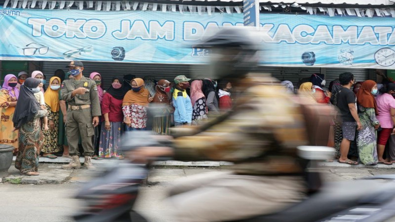 Petugas melayani pembelian minyak goreng murah dalam operasi pasar minyak goreng dan gula pasir di Wonodadi, Blitar, Jawa Timur, Kamis (10/2/2022). (ANTARA FOTO/Destyan Sujarwoko)