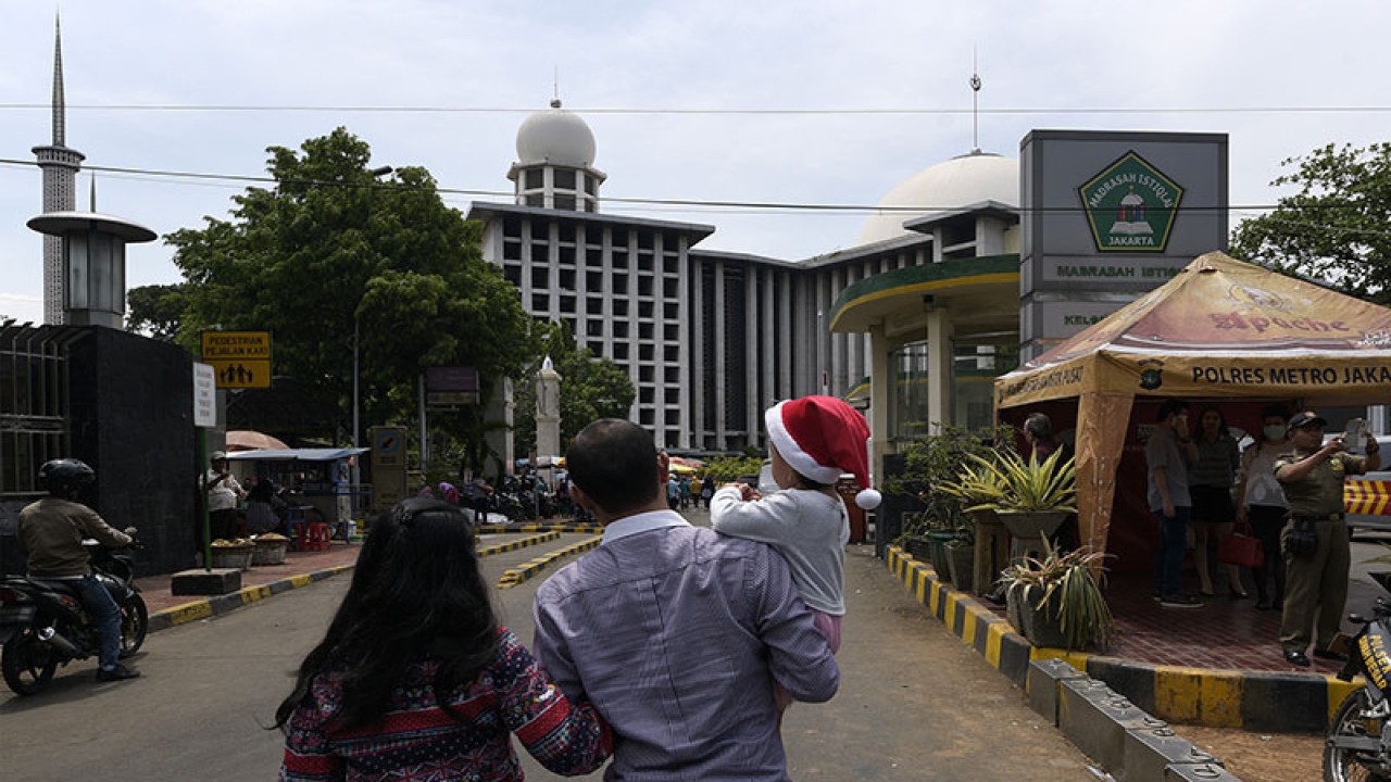 Umat Katolik menuju lokasi parkiran Masjid Istiqlal seusai mengikuti Misa Natal di Gereja Katedral, Jakarta, Jumat (25/12). Pengelola Masjid Istiqlal menyediakan tempat parkir bagi jemaat gereja yang akan melaksanakan Misa Natal sebagai bentuk toleransi yang dijalin antara panitia Gereja Katedral dan pengelola Istiqlal. ANTARA FOTO/Sigid Kurniawan/aww.