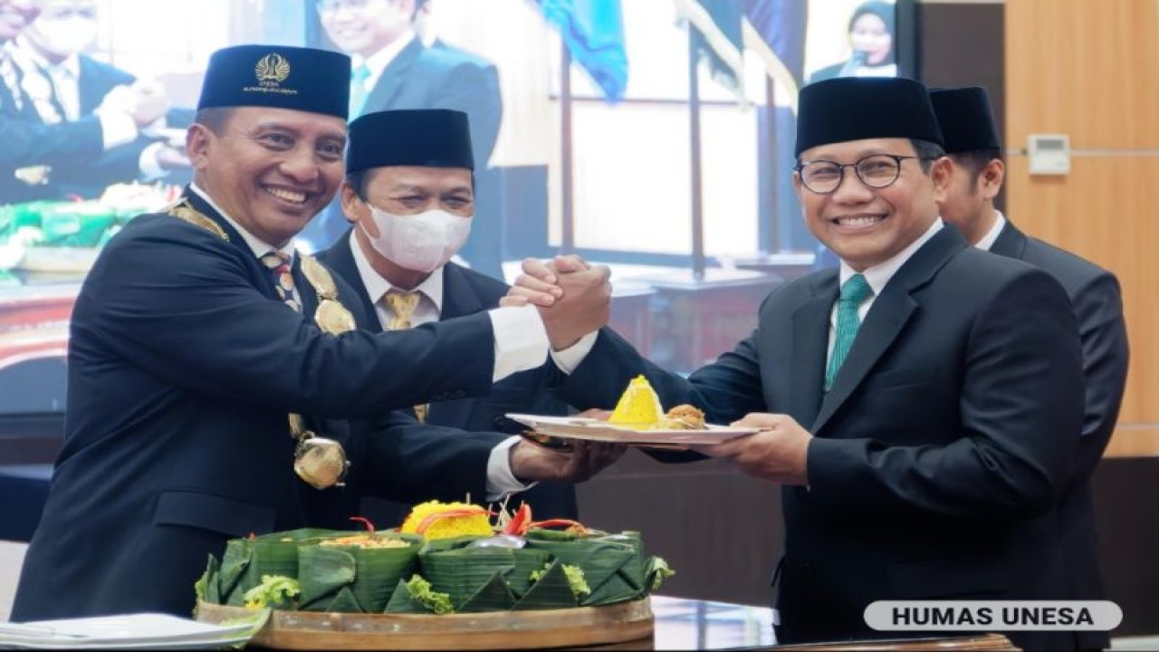 Profesor Nurhasan memberikan potongan tumpeng kepada Menteri Desa, Pembangunan Daerah Tertinggal, dan Transmigrasi (Mendes PDTT) Abdul Halim Iskandar usai dilantik sebagai Rektor Universitas Negeri Surabaya periode 2022-2027, Senin (19/12/2022). (ANTARA/HO-Humas Unesa)