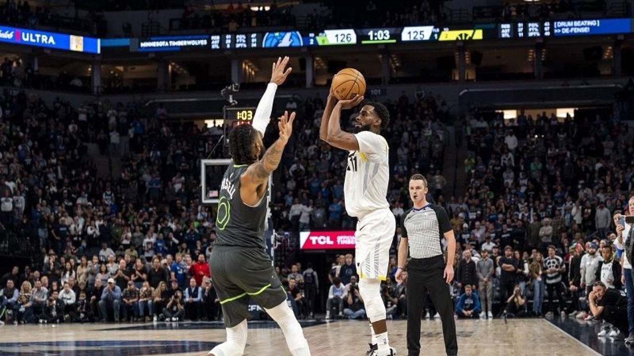 Foto arsip - Pebasket Utah Jazz Mike Conley (kanan) melepaskan tembakan tripoin di hadapan pemain Minnesota Timberwolves D'Angelo Russell dalam lanjutan NBA di Target Center, Minneapolis, Amerika Serikat, Jumat (21/10/2022) waktu setempat. (ANTARA/AFP/GETTY IMAGES/Stephen Maturen)