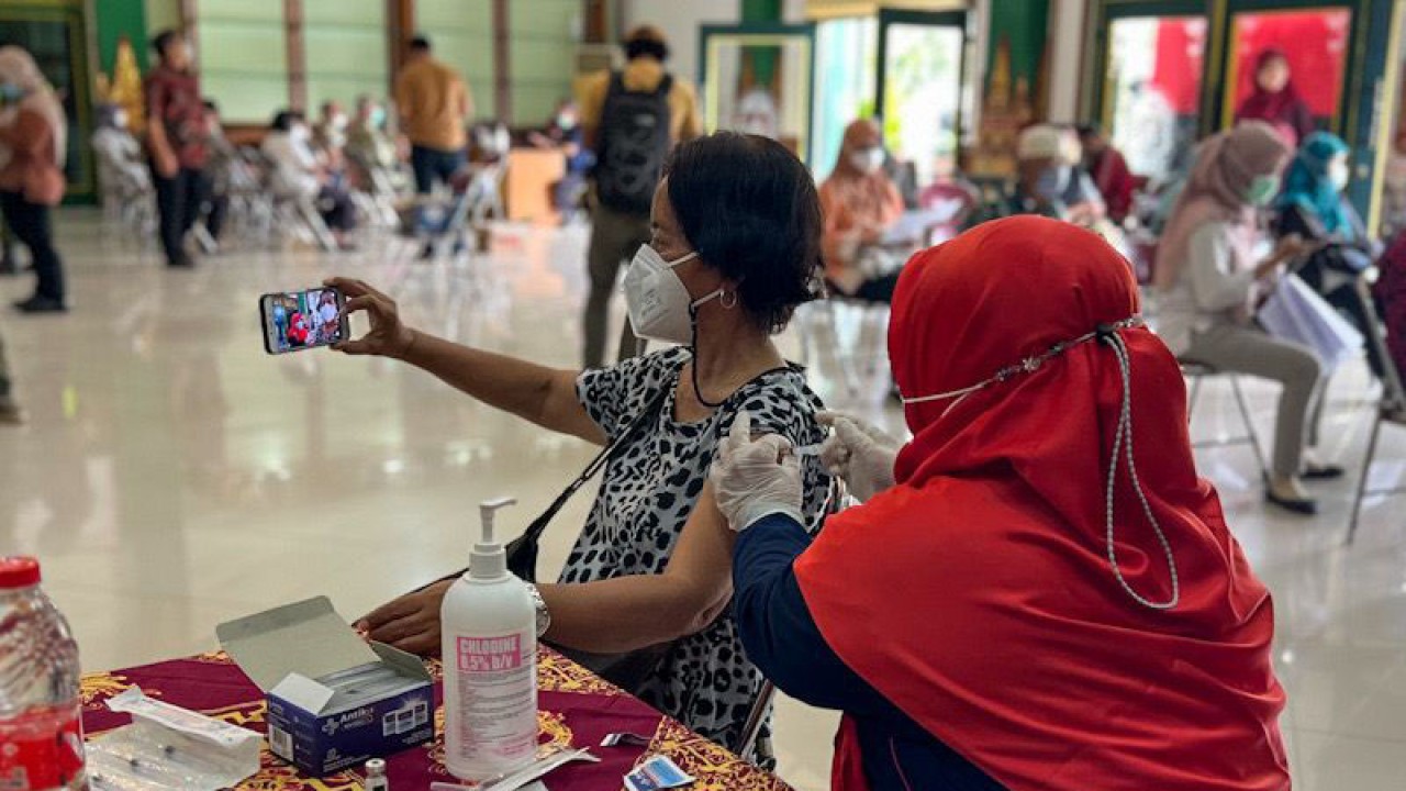 Warga lansia berswafoto saat menjalani vaksinasi COVID-19 pada pencanangan pelaksanaan vaksinasi booster kedua bagi warga lansia di Kota Yogyakarta, Kamis (15/12/2022). (ANTARA/Eka AR)