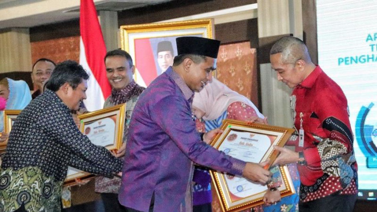 Wakil Gubernur Jateng Yasin Maimoen menyerahkan piagam penghargaan kepada Bupati Kudus Hartopo atas capaian target Universal Health Coverage (UHC) atau cakupan kesehatan menyeluruh bagi penduduk dengan capaian 95,42 persen penduduknya mengikuti program Jaminan Kesehatan Nasional-Kartu Indonesia Sehat (JKN-KIS). ANTARA/HO-Hms Pemkab Kds.