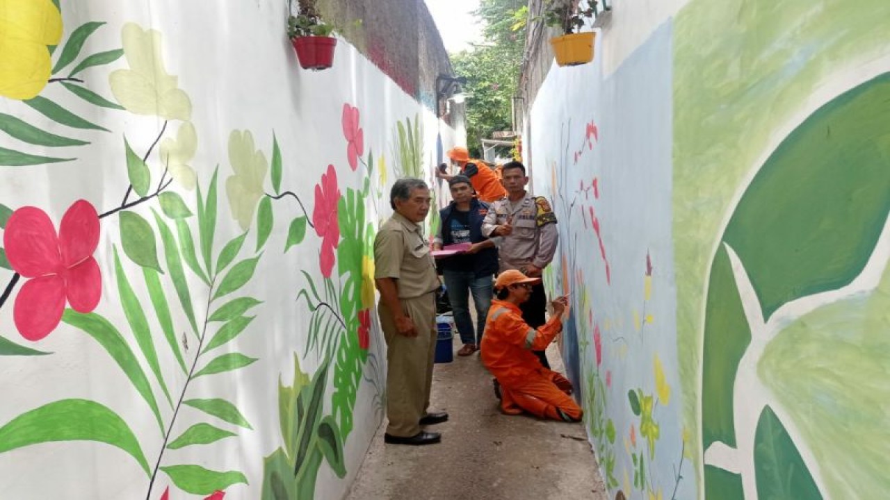 Sejumlah personel Polsek Cilandak membantu warga melukis tembok di Jalan Swakarya Bawah RT005/RW09, Pondok Labu, Jakarta, Kamis (15/12/2022). ANTARA/HO-Polsek Cilandak