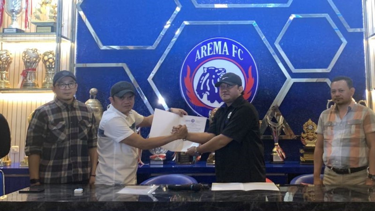 Komisaris PT Arema Aremania Bersatu Berprestasi (PT AABBI), Tatang Dwi Arifianto (kedua kiri) menyerahkan Surat Keputusan (SK) Manajer Arema FC kepada Wiebie Dwi Andriyas, di Kota Malang, Jawa Timur, Senin (5/12/2022). (ANTARA/Vicki Febrianto)