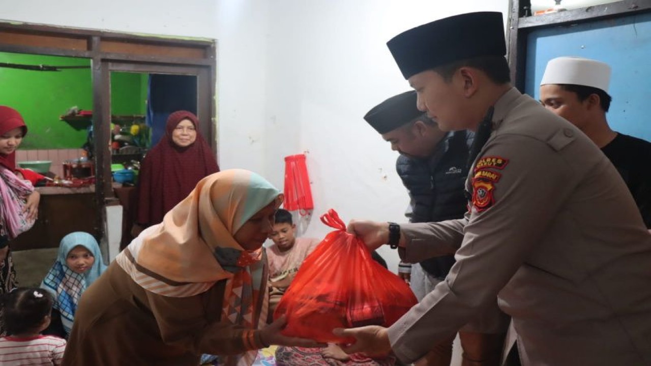 Kepala Kepolisian Resor Garut AKBP Wirdhanto Hadicaksono menyerahkan bantuan kepada warga korban gempa Cianjur di Perumahan Bumi Malayu Asri, Desa Mekarwangi, Kecamatan Tarogong Kaler, Kabupaten Garut, Jawa Barat, Jumat (16/12/2022). ANTARA/HO-Humas Polres Garut