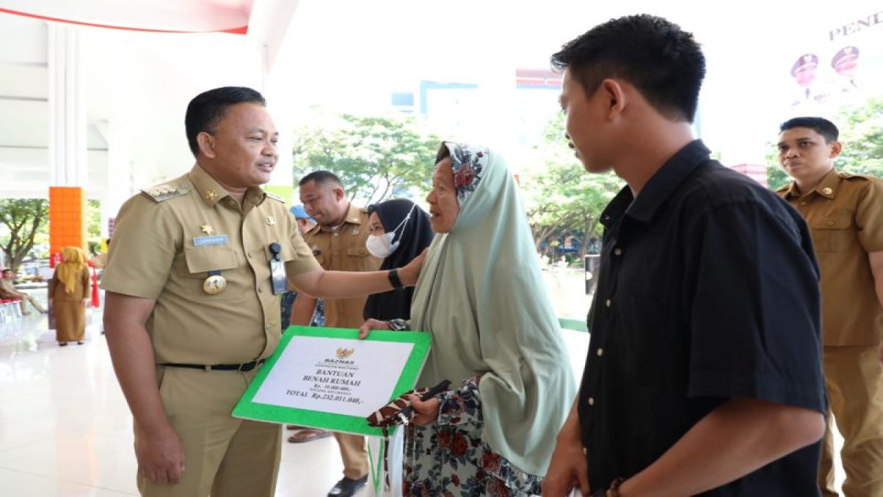 Bupati Bantaeng Ilham Azikin secara simbolis menyerahkan bantuan dana kepada warga yang berhak menerima zakat atau mustahik. (ANTARA/HO-Humas Pemkab Bantaeng)