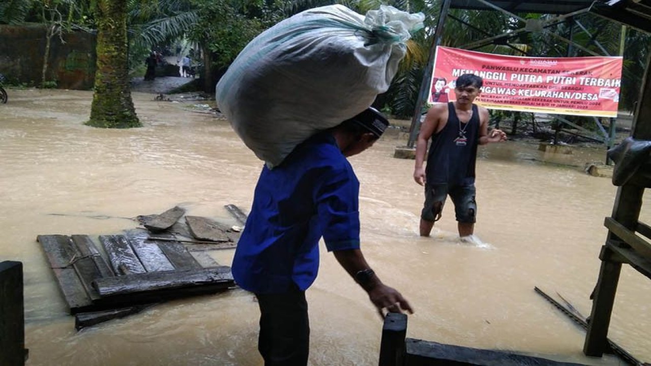 Warga menyelamatkan barang setelah rumah mereka terdampak banjir di Kabupaten Aceh Tamiang, Sabtu (21/1/2023). ANTARA/HO/BPBA