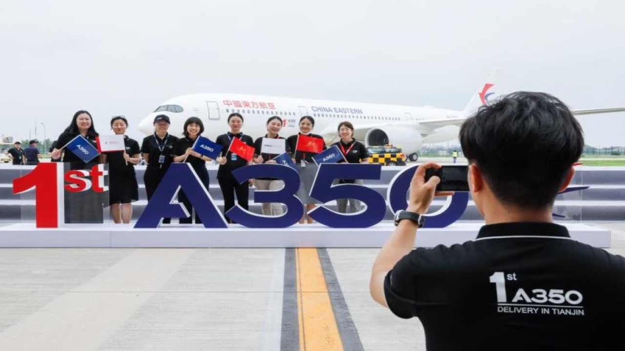Foto Dokumen: Anggota staf berpose untuk foto bersama di depan pesawat Airbus A350 yang dikirim ke China Eastern Airlines di Airbus Tianjin Widebody Completion and Delivery Center di Tianjin, China Utara, 21 Juli 2021. ANTARA/Xinhua/Zhang Yuwei