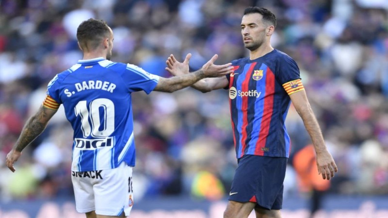 Gelandang Barcelona Sergio Busquets (kanan) bersalaman dengan gelandang Espanyol Sergi Darder pada akhir pertandingan LaLiga antara FC Barcelona dan RCD Espanyol di Stadion Camp Nou di Barcelona pada 31 Desember 2022. (Photo by Pau BARRENA / AFP) (AFP/PAU BARRENA)