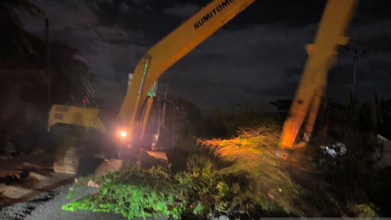 Satu unit alat berat dikerahkan untuk mengangkat sampah yang menutup aliran Kali Sepak area Tol Cibitung-Cilincing tepat di depan Gerbang Tol Gabus, Desa Srijaya, Kecamatan Tambun Utara, Kabupaten Bekasi, Jawa Barat pada Selasa (10/1/2023) malam. (ANTARA/Pradita Kurniawan Syah).