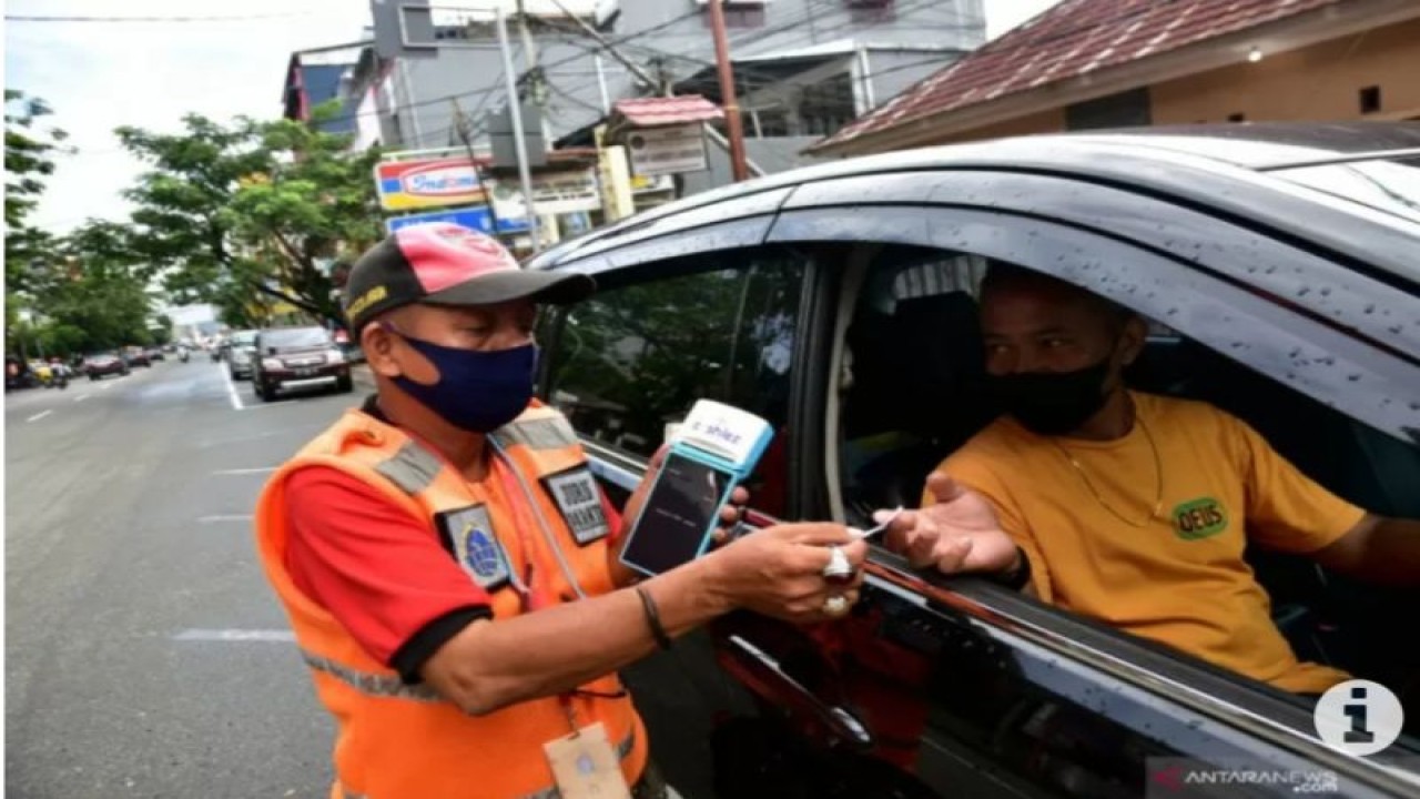 Seorang petugas (kiri) memberikan layanan parkir kendaraan kepada warga Kota Ambon. ANTARA