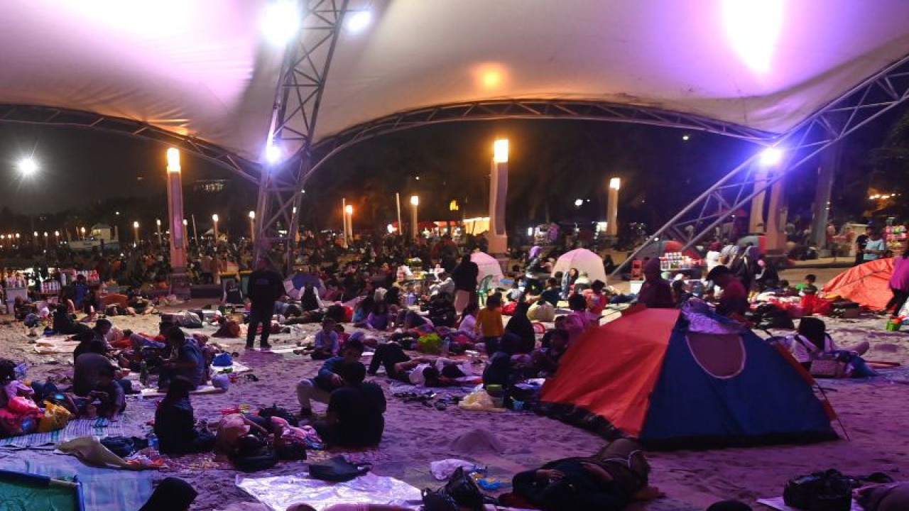 Sejumlah wisatawan menghabiskan malam pergantian tahun di Pantai Lagoon, Taman Impian Jaya Ancol, Jakarta, Sabtu (31/12/2022). Pantai di Ancol menjadi salah satu destinasi favorit warga Jakarta dan daerah-daerah lainnya dalam menghabiskan malam pergantian tahun karena menawarkan pertunjukan musik dan kembang api. ANTARA FOTO/Aditya Pradana Putra/aww.