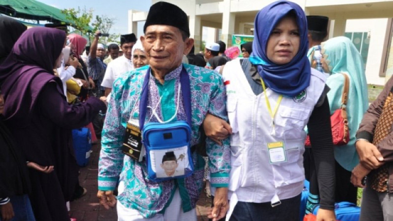 Arsip Foto. Petugas membantu anggota jamaah haji lanjut usia (lansia) menuju ke mobil yang akan membawa mereka ke asrama haji. (ANTARA/Moh Ridwan)