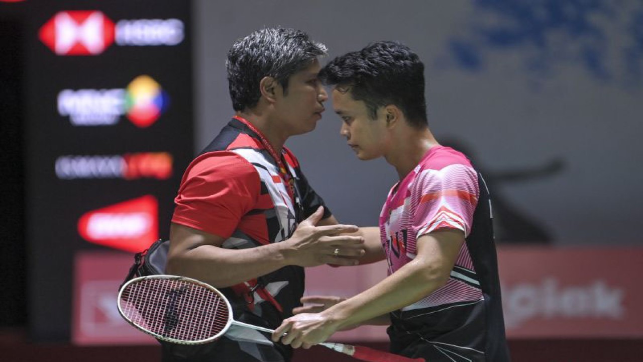 Pebulu tangkis tunggal putra Indoneia Anthony Sinisuka Ginting (kanan) berjabat tangan dengan pelatihnya Irwansyah (kiri) usai menang atas lawannya pebulu tangkis tunggal putra Hongkong Lee Cheuk Yu pada babak 32 besar turnamen Daihatsu Indonesia Masters 2023 di Istora Gelora Bung Karno, Senayan, Jakarta, Rabu (25/1/2023). . ANTARA FOTO/M Risyal Hidayat/foc (ANTARA FOTO/M RISYAL HIDAYAT)