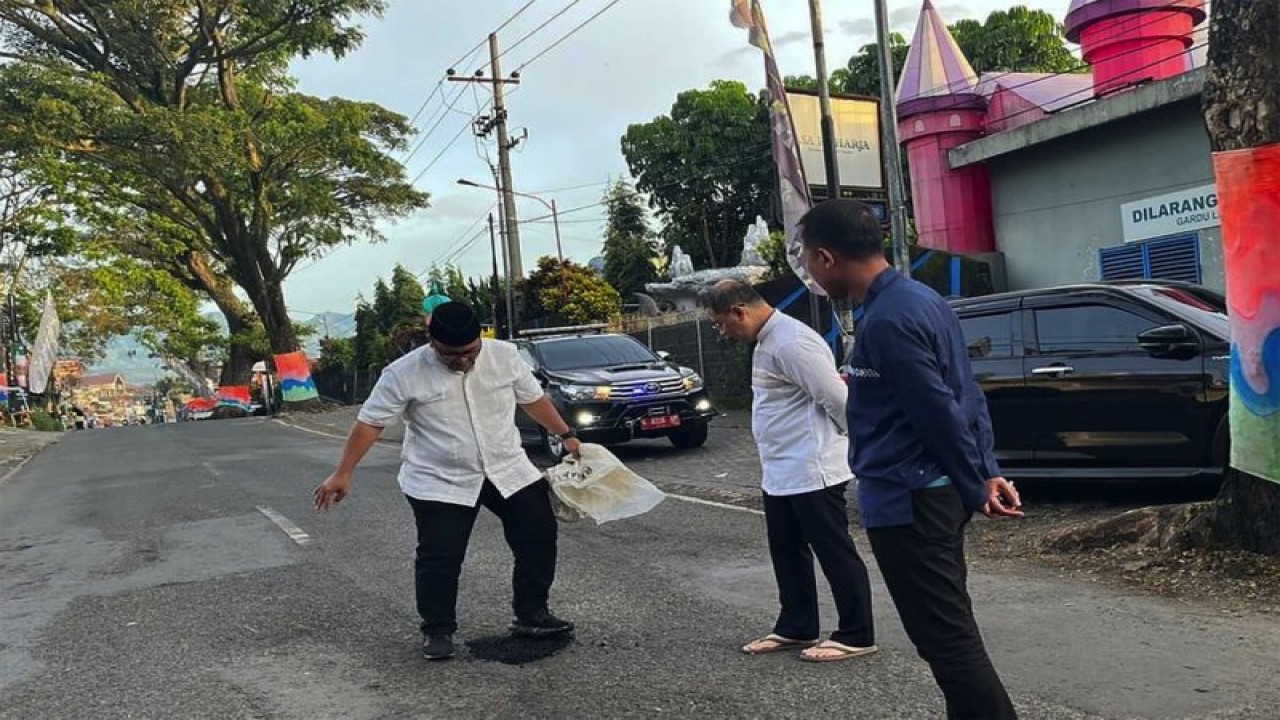 Penjabat (Pj) Wali Kota Batu Aries Agung Paewai (tengah) pada saat melihat proses penambalan jalan rusak di salah satu titik di Kota Batu, Jawa Timur, Senin (23/1/2023). (FOTO ANTARA/HO-Humas Pemkot Batu.)