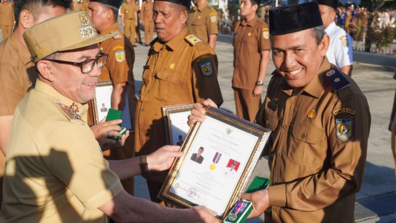 Pj Wali Kota Banda Aceh Bakri Siddiq (kiri) saat memberikan sertifikat desa mandiri kepada salah seorang kepala desa, di Banda Aceh, Senin (2/1/2023) (ANTARA/HO/Media Center Banda Aceh)