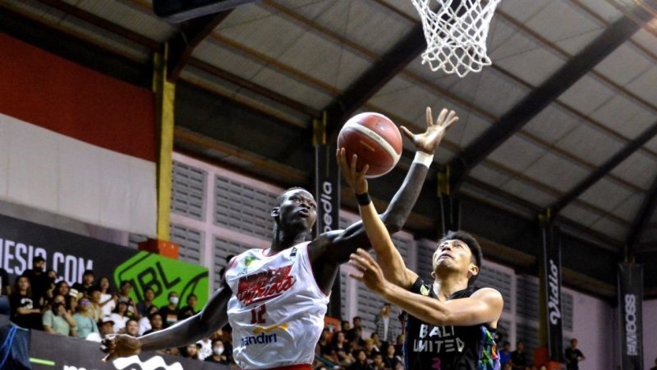 Pebasket Bali United Basketball Handri Satrya Santosa (kanan) berusaha memasukkan bola dan dihadang pebasket Indonesia Patriots Dame Diagne (kiri) pada pertandingan Indonesian Basketball League (IBL) 2023 di GOR Merpati, Denpasar, Bali, Senin (16/1/2023). ANTARA FOTO/Fikri Yusuf/tom. (ANTARA FOTO/FIKRI YUSUF)